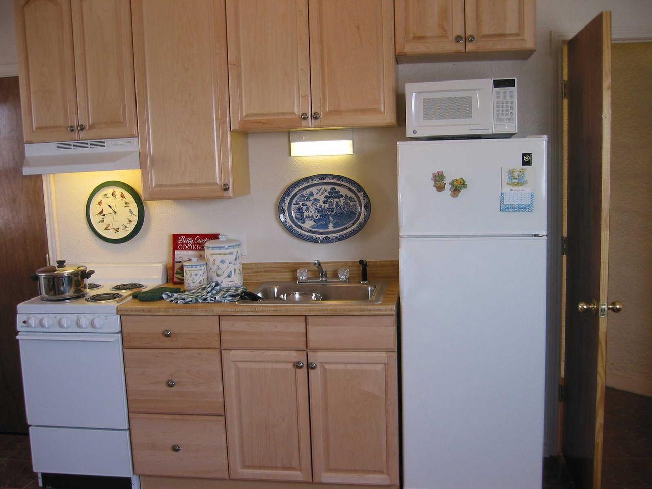 Kitchen with range, fridge, and microwave.